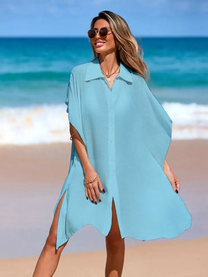 Pastel blue button-up cover-up with short sleeves and high side slits, worn on the beach.