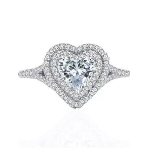 Silver ring with a heart-shaped moissanite center stone and a double diamond halo.