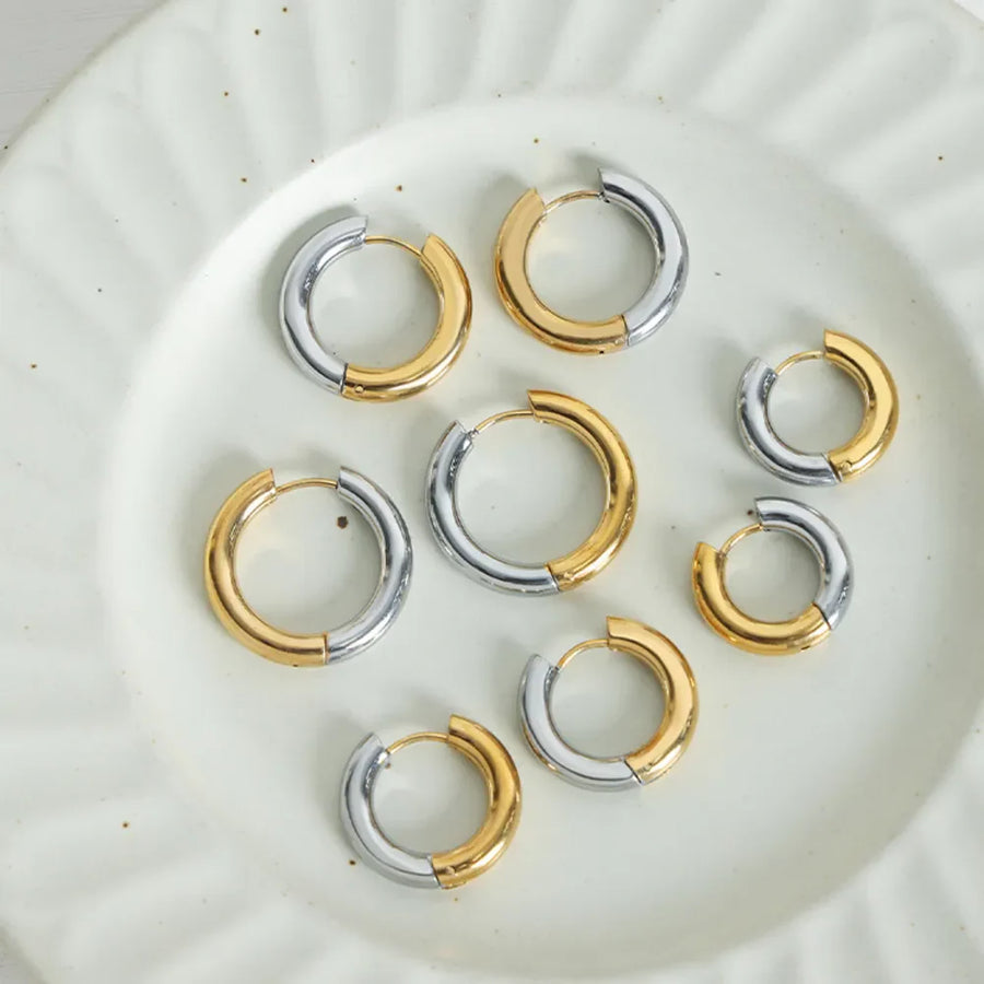 Two-tone segmented hoop earrings in gold and silver with a polished finish.
