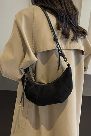 Black suede crescent shoulder bag with knot detail and gold hardware