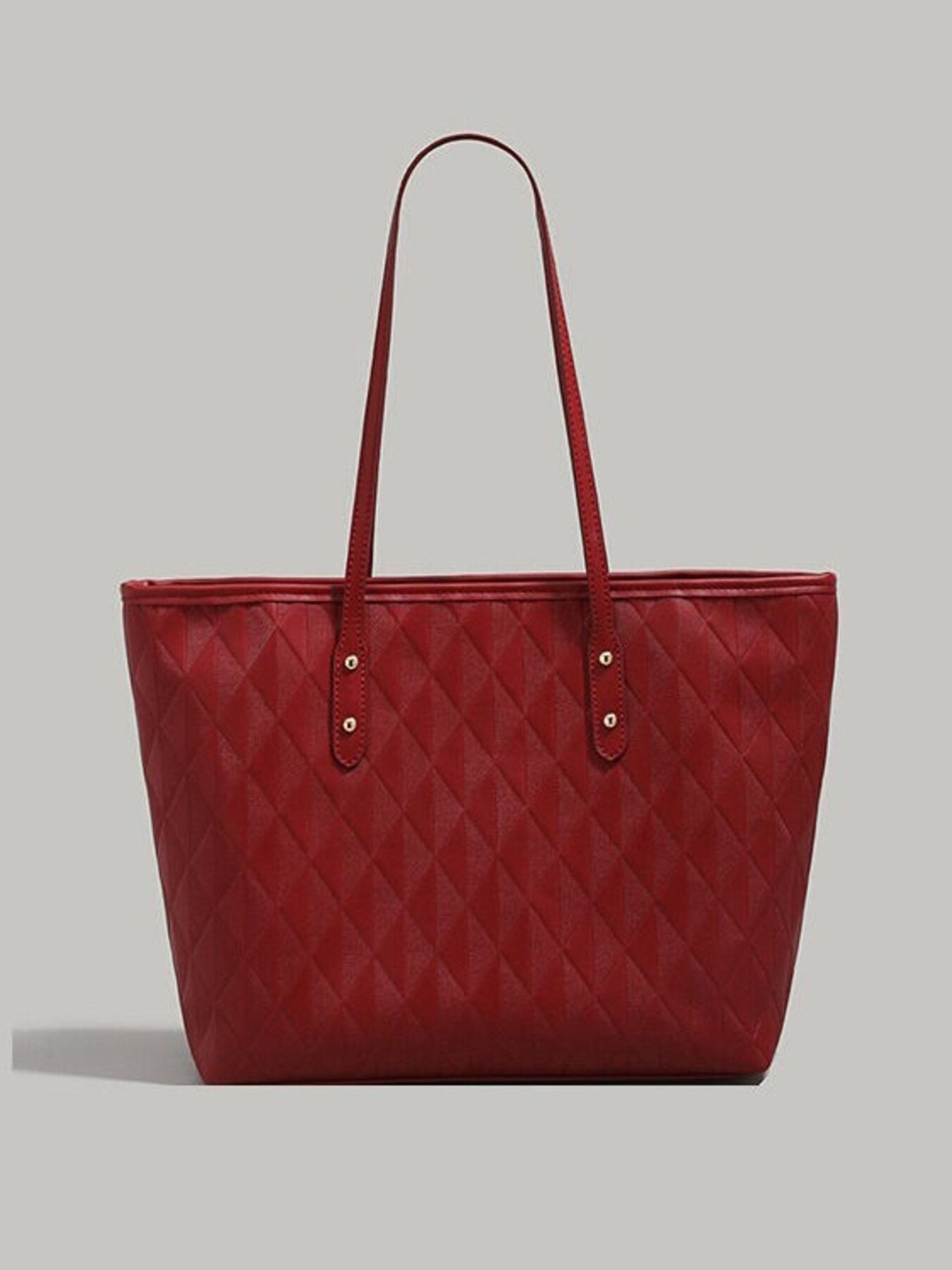 Red quilted pu leather tote bag with diamond pattern and double straps.