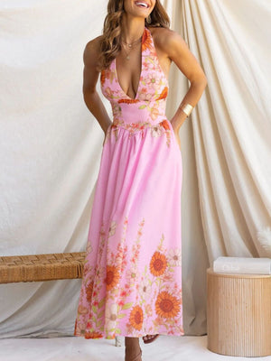 Pink floral halter neck maxi dress with a deep V-neckline and flowing skirt.
