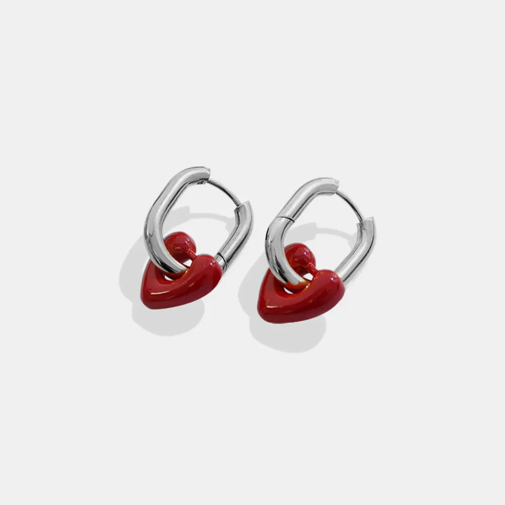 Crimson heart enamel hoop earrings with silver metal hoops.