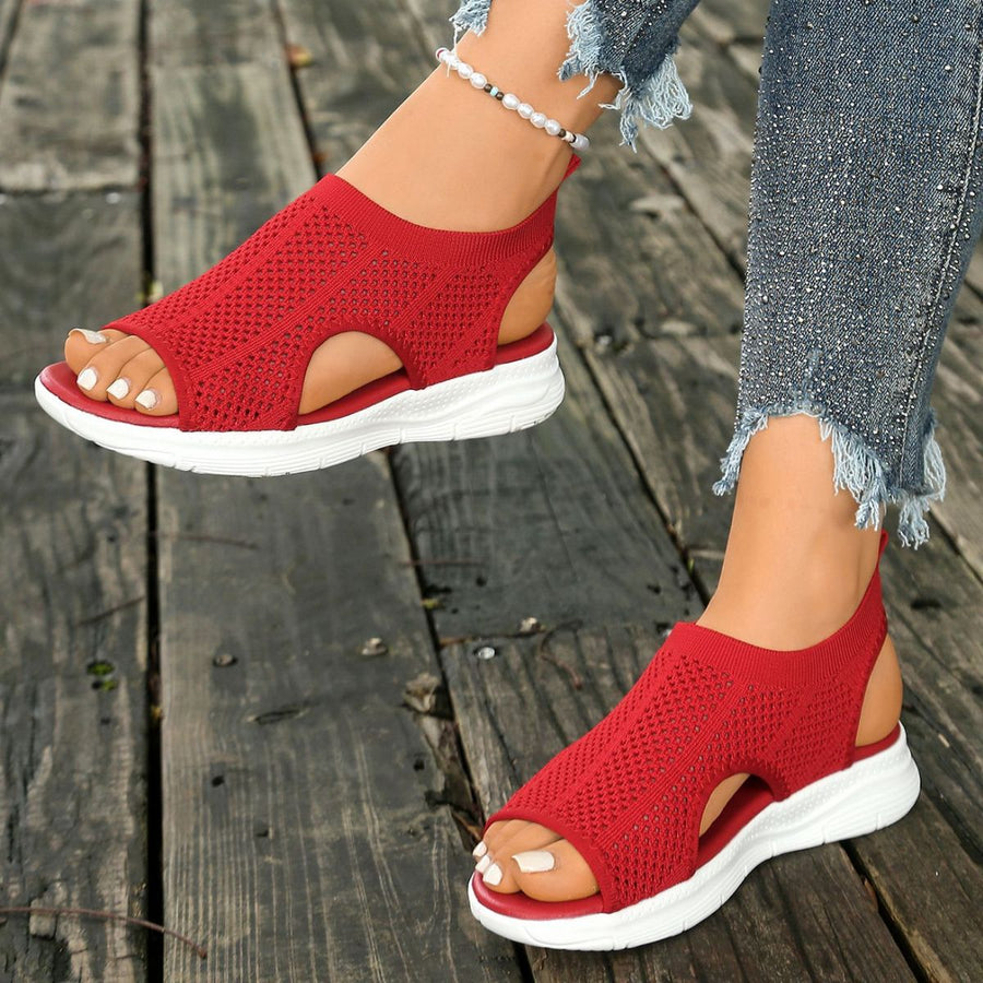 Red mesh open-toe sandals with a chunky white sole and casual cut.