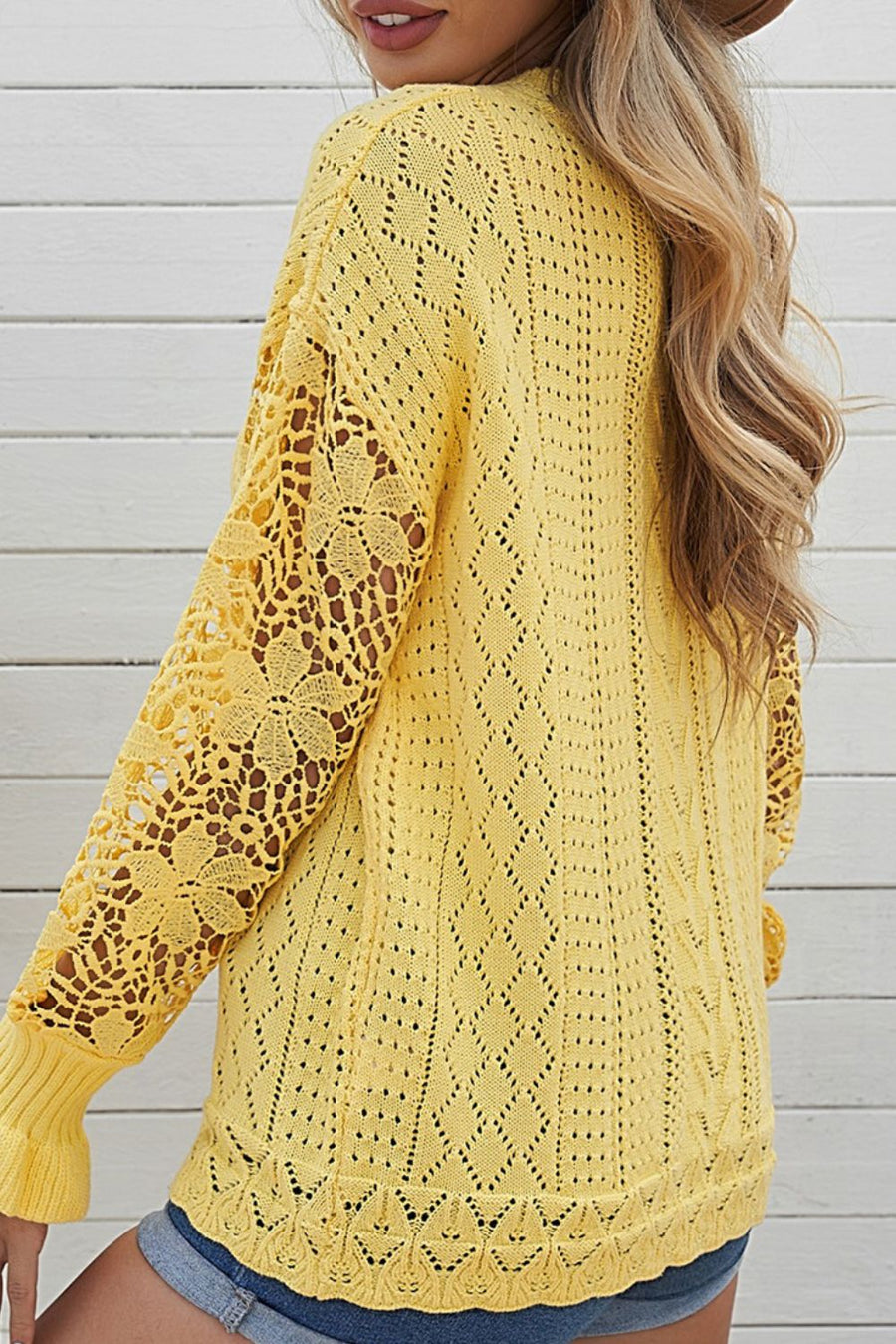 Yellow openwork knit sweater with lace sleeves and diamond pattern.