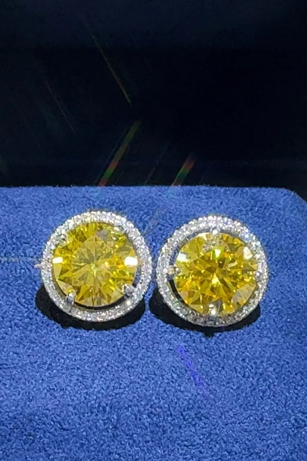 Canary yellow moissanite halo stud earrings in gold with a diamond-like sparkle.