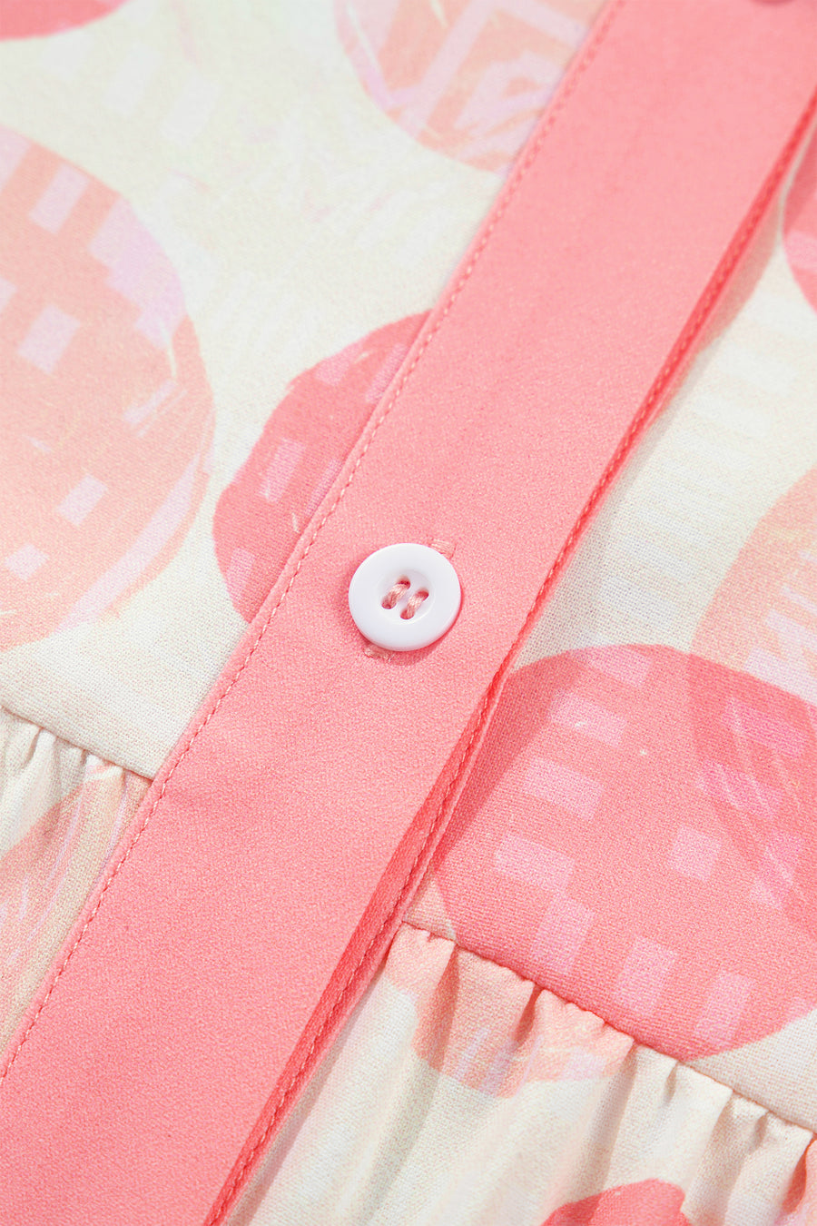 Polka dot babydoll shirt with pink ruffle trim and button detail.