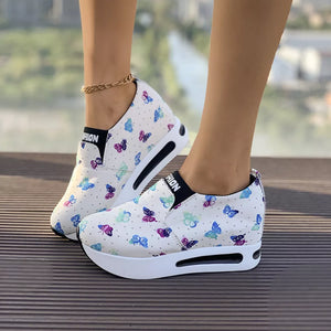 White butterfly print slip-on flats with air cushion sole and black trim.