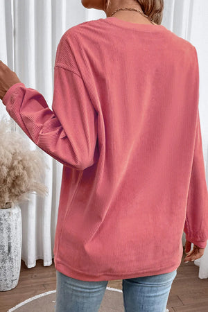Textured corduroy sweatshirt in burnt coral with long sleeves and a relaxed fit.
