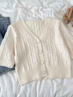 Chic cable-knit cropped cardigan in apricot with button front and V-neck.