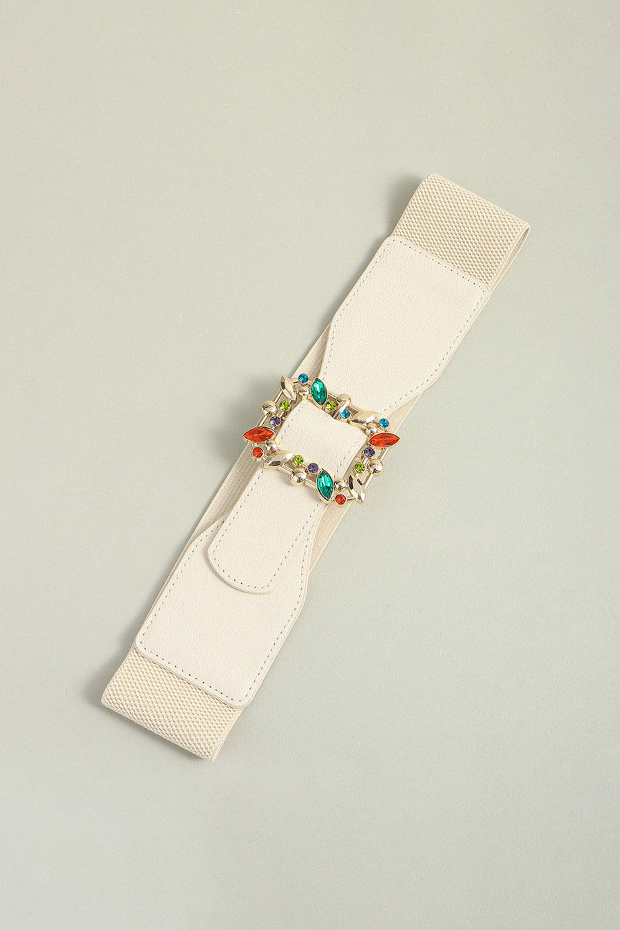 Ivory elasticated belt with a gold buckle adorned with colorful rhinestones.