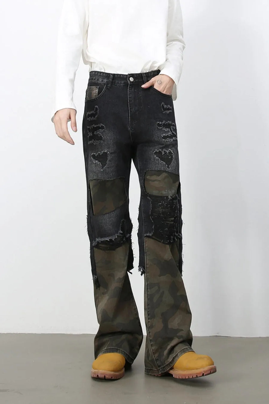 Distressed dark wash flare jeans with camo panels and ripped details.