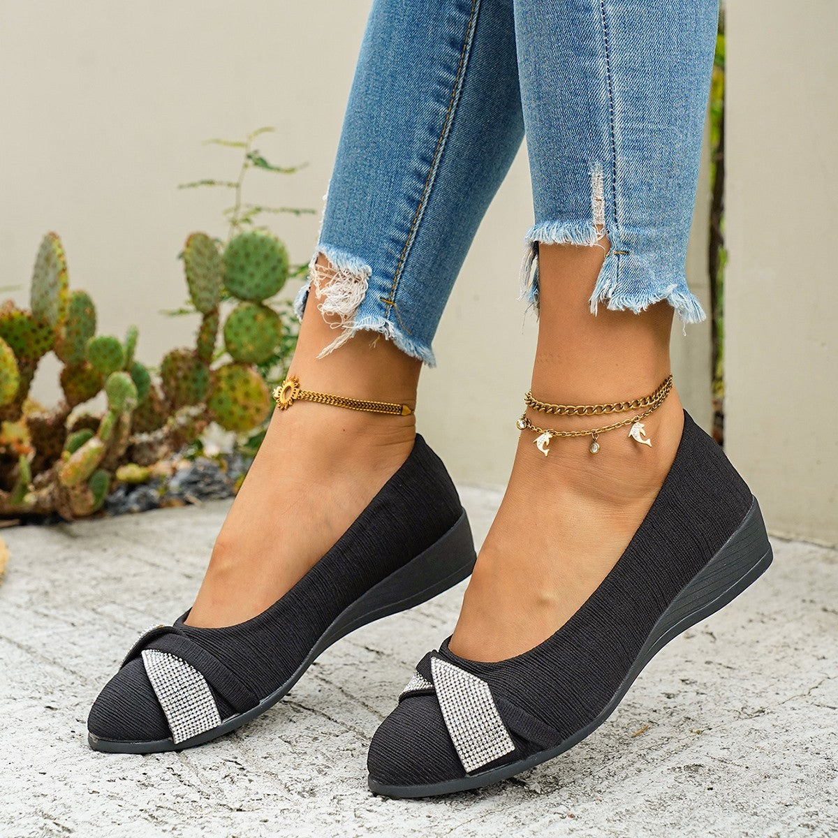 Black slip-on wedge flats with rhinestone bow detail