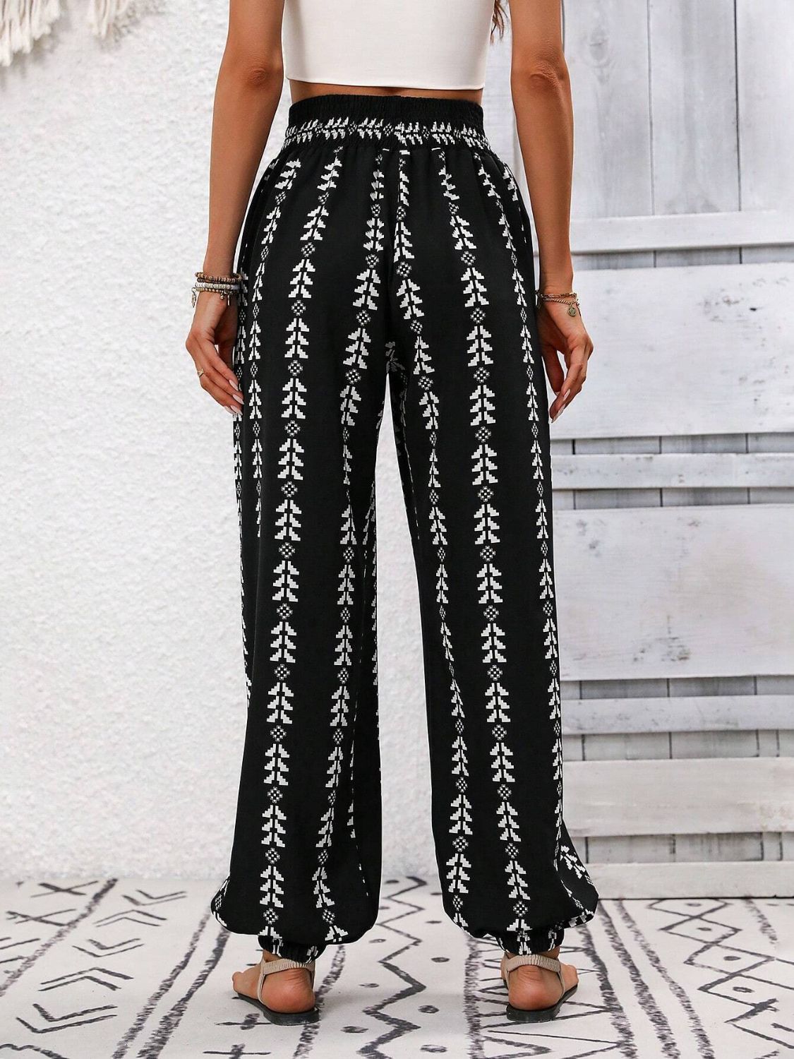 Black ankle trousers with white leaf print and gathered cuffs.
