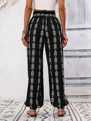 Black ankle trousers with white leaf print and gathered cuffs.