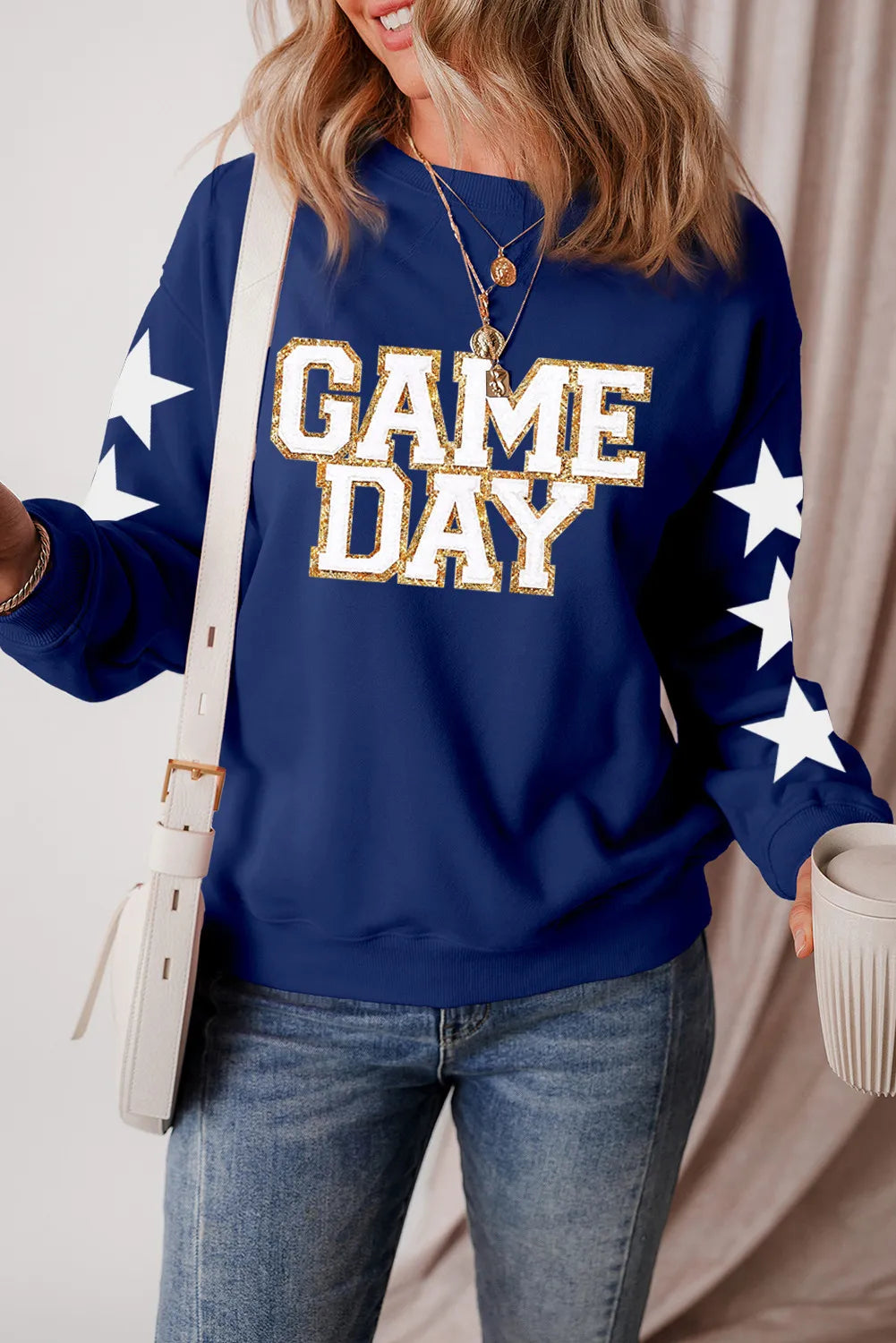 Navy sweatshirt with white stars on sleeves and "GAME DAY" glitter graphic.
