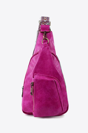 Textured magenta sling bag with woven strap detail and zippered pocket