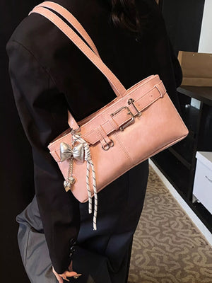 Blush pink shoulder bag with buckle detail and bow charm