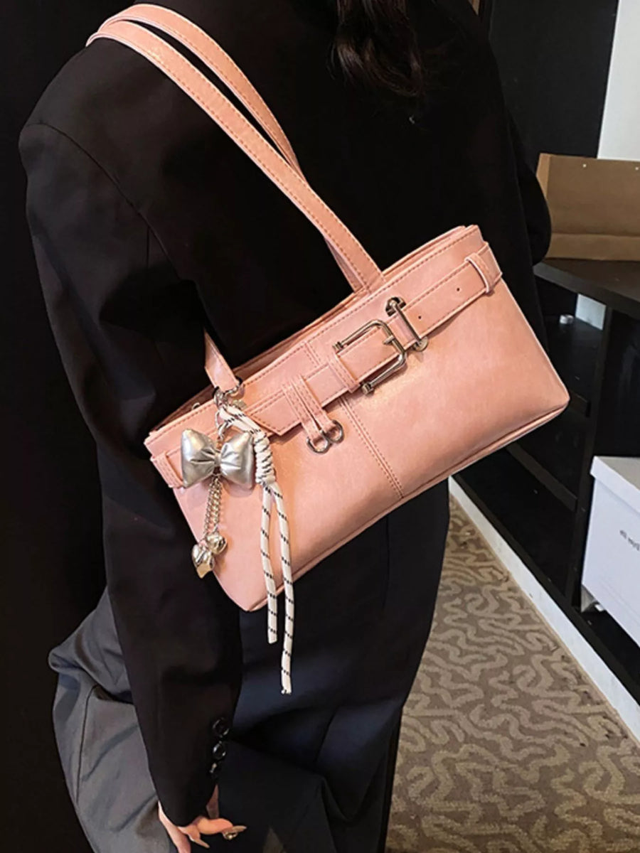 Blush pink shoulder bag with buckle detail and bow charm