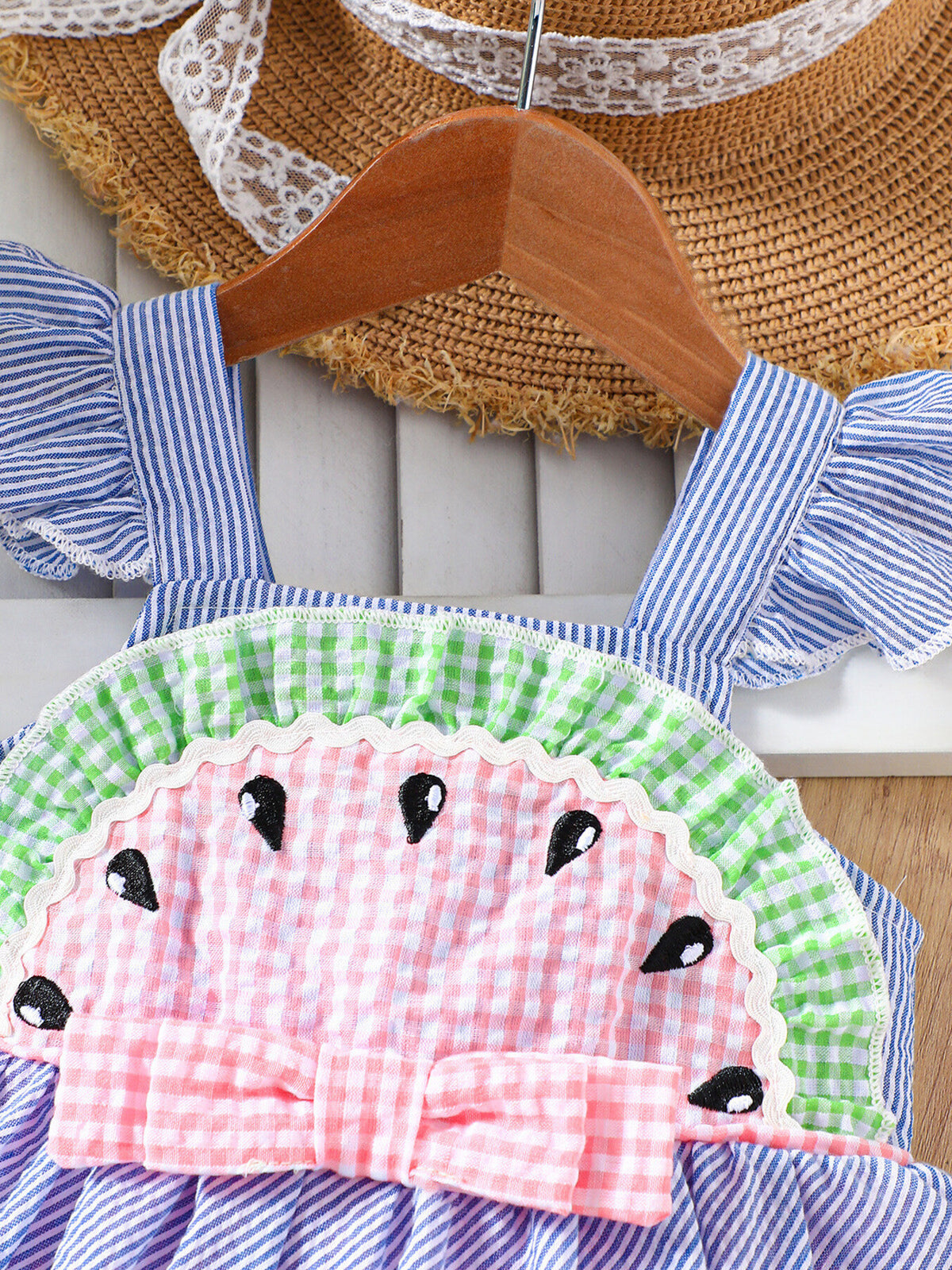Baby dress with watermelon applique, ruffle sleeves, and bow detail.