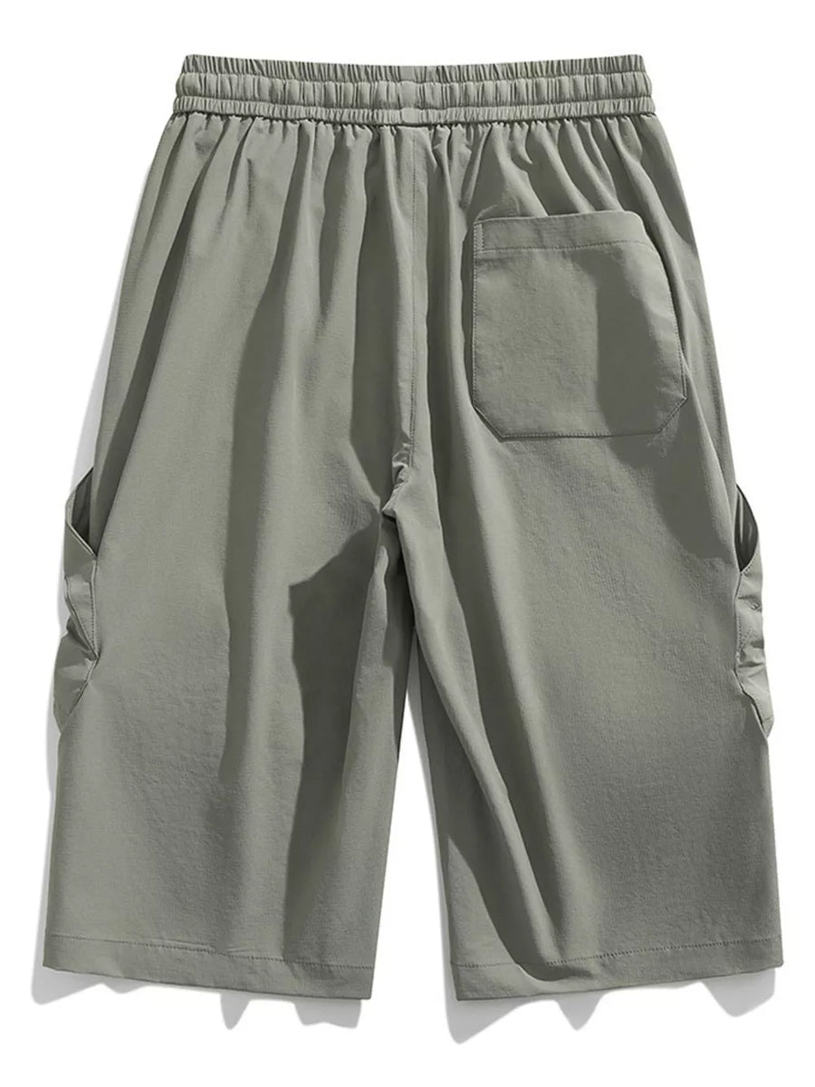 Light gray cargo capris with elastic waistband and drawstring, featuring side pockets and a back pocket.