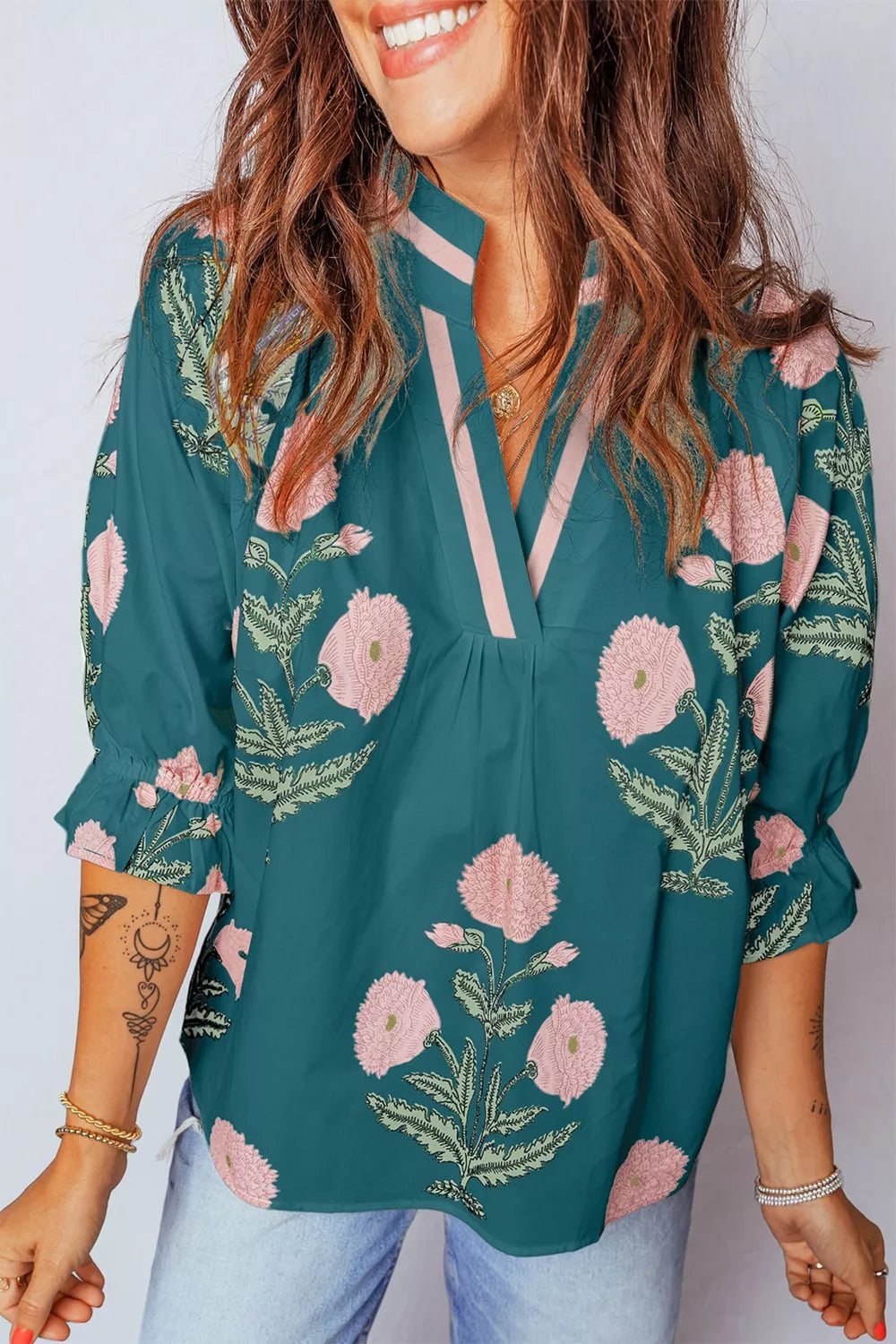 Dark green cotton blend blouse with pink floral embroidery, notched neckline, and ruffled sleeves.