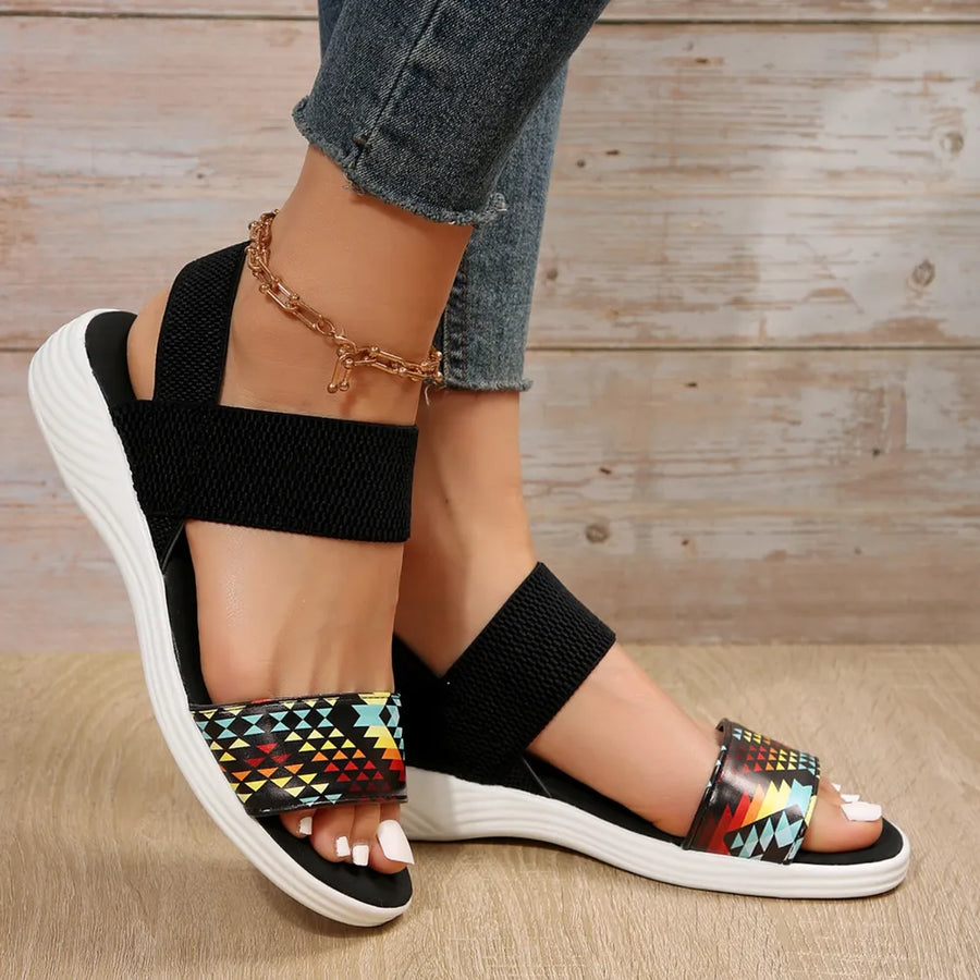 Geometric print elastic strap sandals with black straps and white soles.