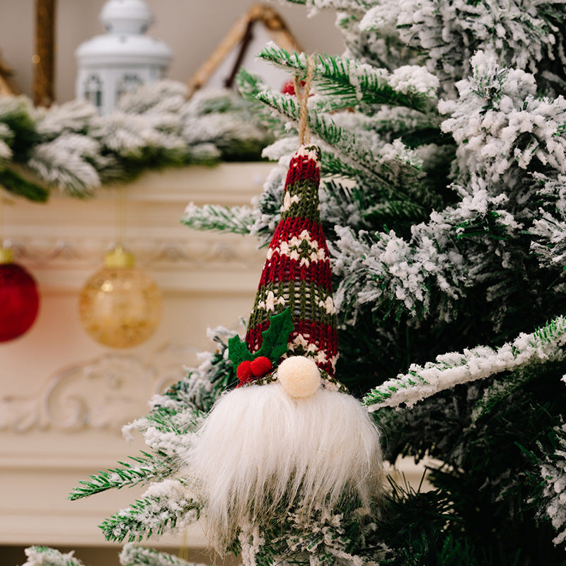 Knitted gnome ornament with red, green, and white striped hat, white beard, and holly detail.
