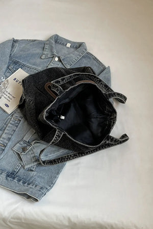 Denim pocket tote bag with leather trim, dark wash, open top.