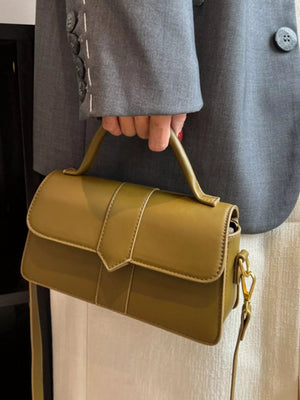 Chic small top handle bag in green with a flap closure and gold hardware.