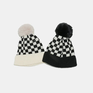 Checkerboard knit beanies with faux fur pom in ivory and black.