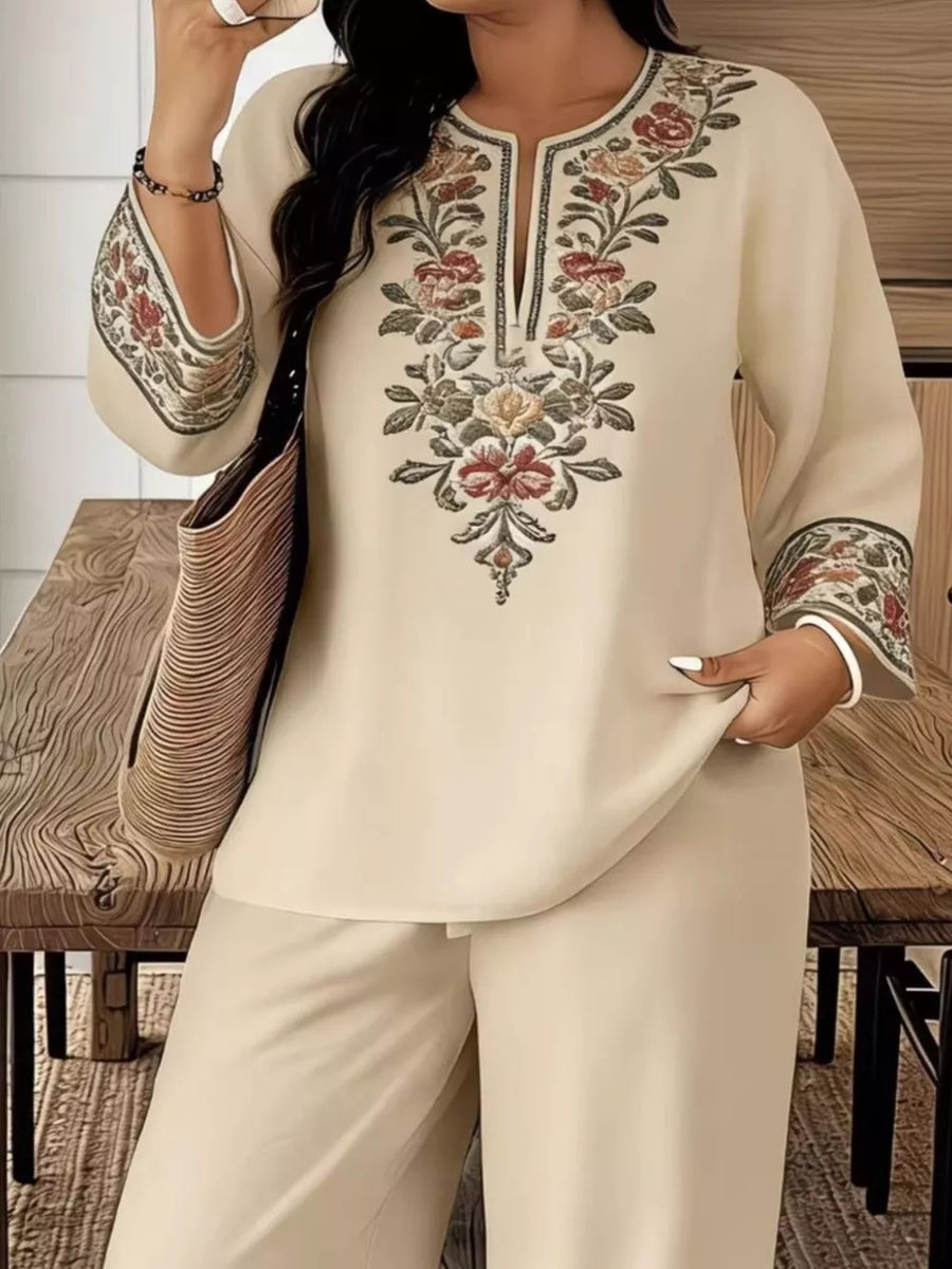 Cream embroidered tunic with floral detail and wide-leg pants.
