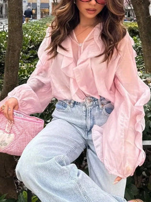 Pink sheer ruffled long-sleeve blouse with voluminous sleeves.