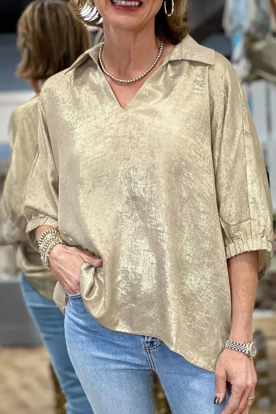 Beige textured blouse with Johnny collar, V-neck, and elastic cuffs.