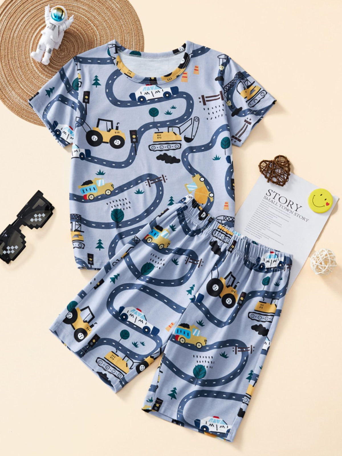 Toddler boys' light blue construction vehicle print pajama set with short sleeves and shorts.
