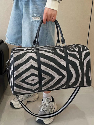 Large black and white zebra print duffle bag with carry handles and detachable strap