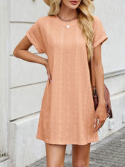 Eyelet mini dress in peach with diamond pattern, crew neck, and short sleeves.