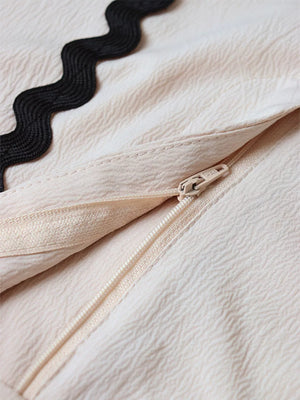 Scalloped trim tank and shorts set in cream with black trim and zipper detail.