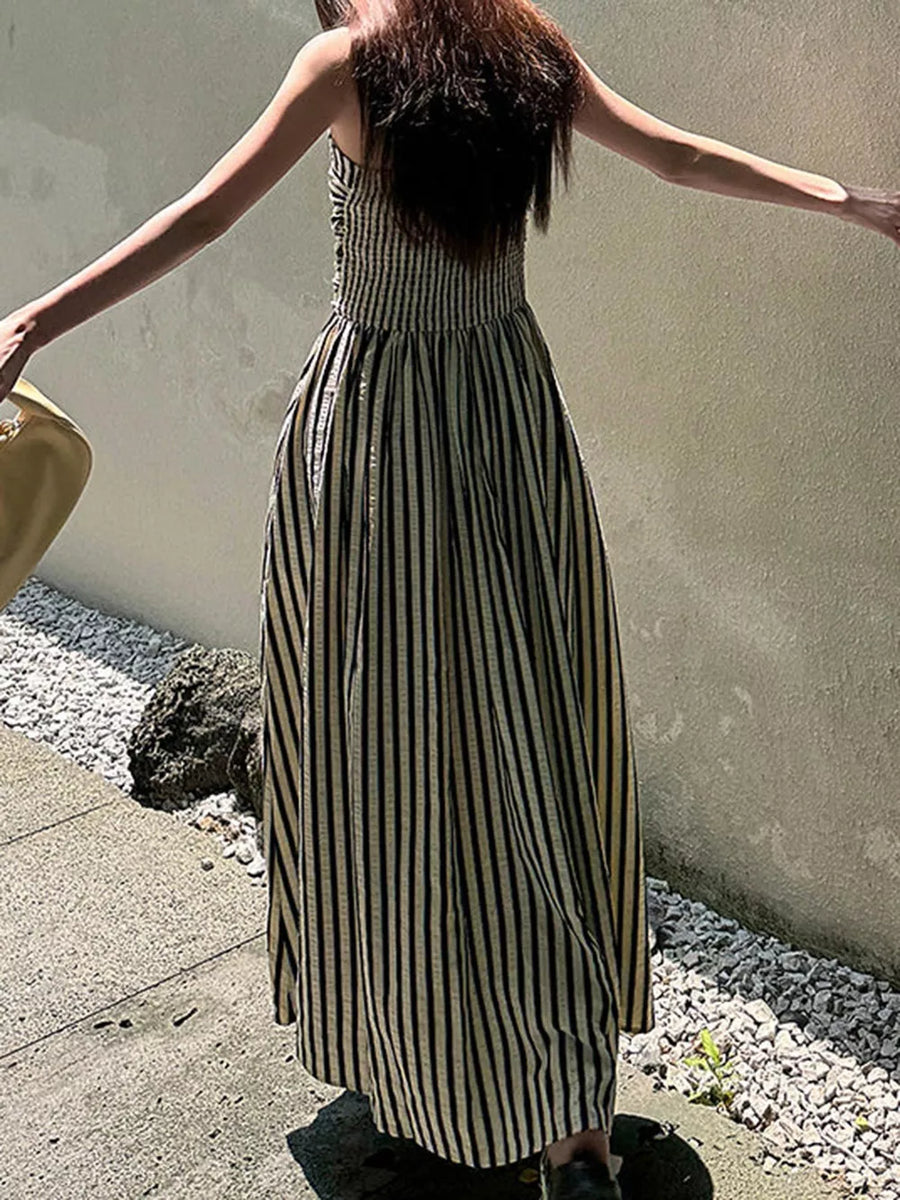 Maxi dress with black and gold stripes, smocked bodice, and a side slit.