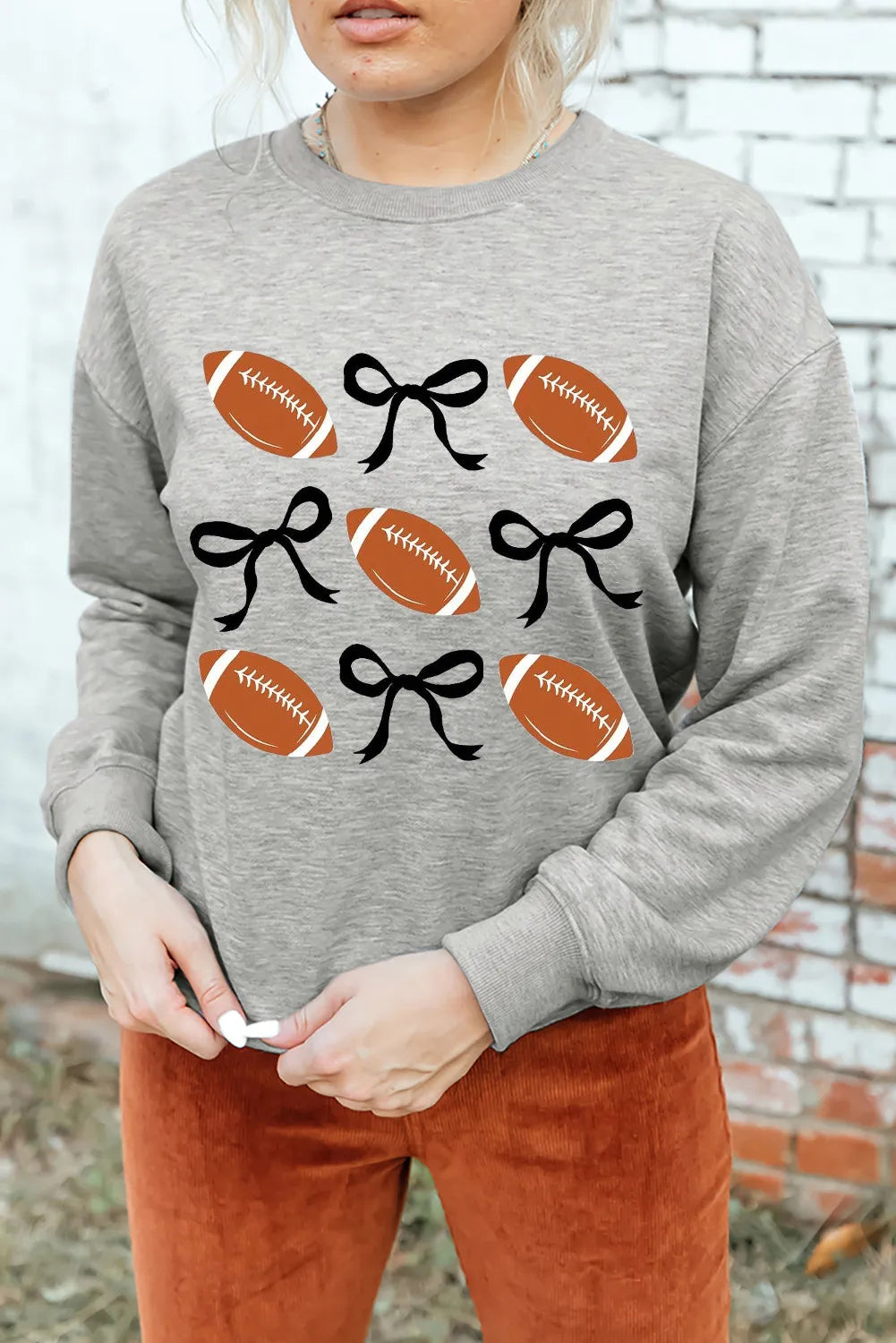 Gray sweatshirt with footballs and black bows graphic print