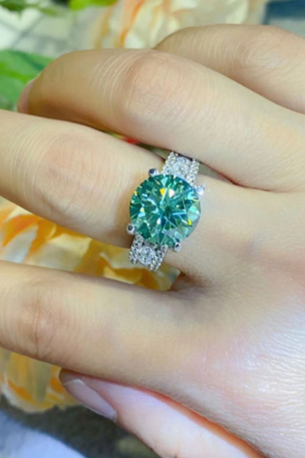 Verdant moissanite pavé band ring with a large, round, light green center stone.