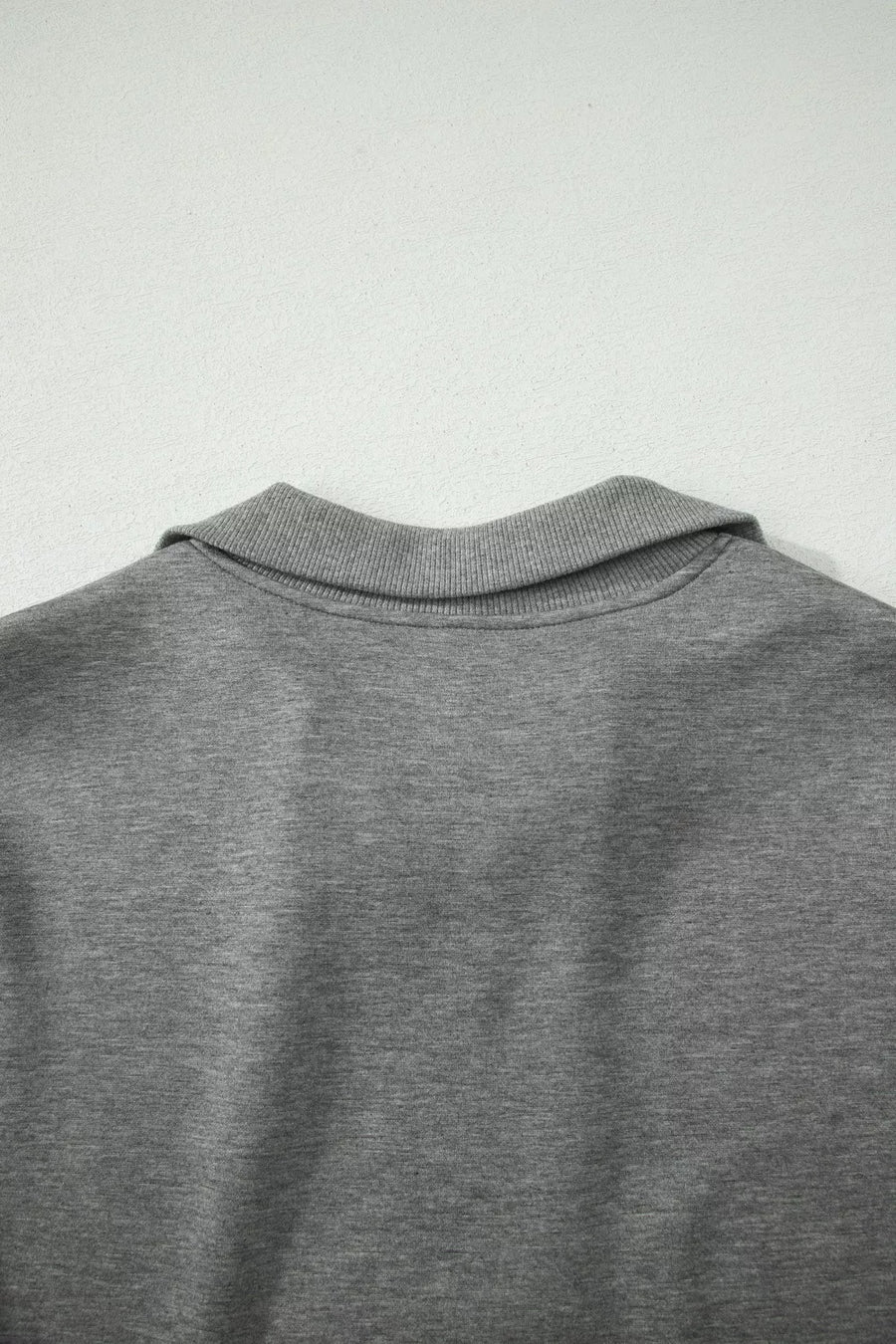 Dark gray half-zip polo sweatshirt detail with ribbed collar