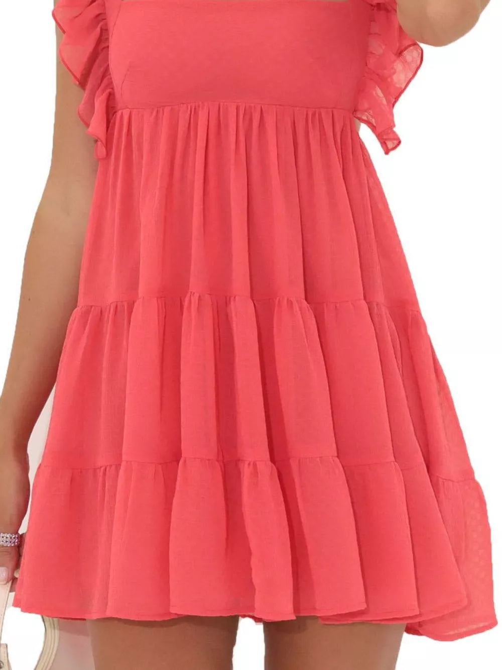 Tiered mini dress in watermelon red with ruffled square neck and flutter sleeves.