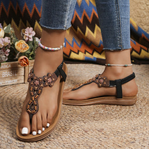 Bohemian beaded sandals in brown with ankle strap and intricate floral beadwork.