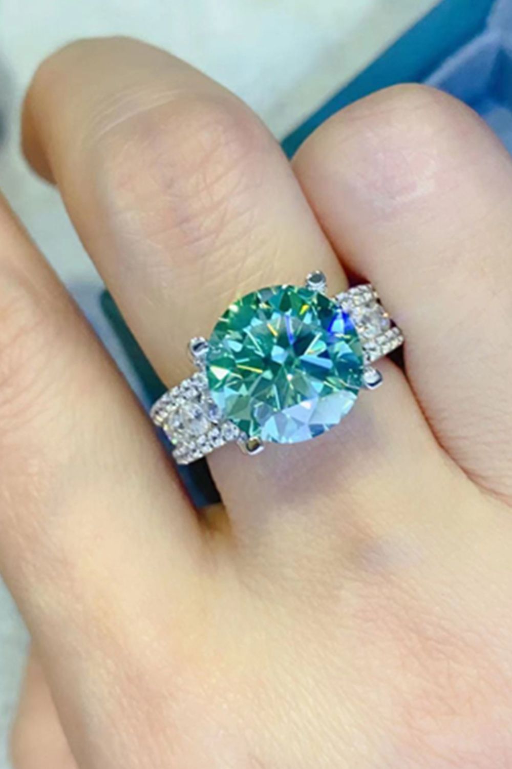 Verdant moissanite pavé band ring with a large center stone and sparkling side stones.