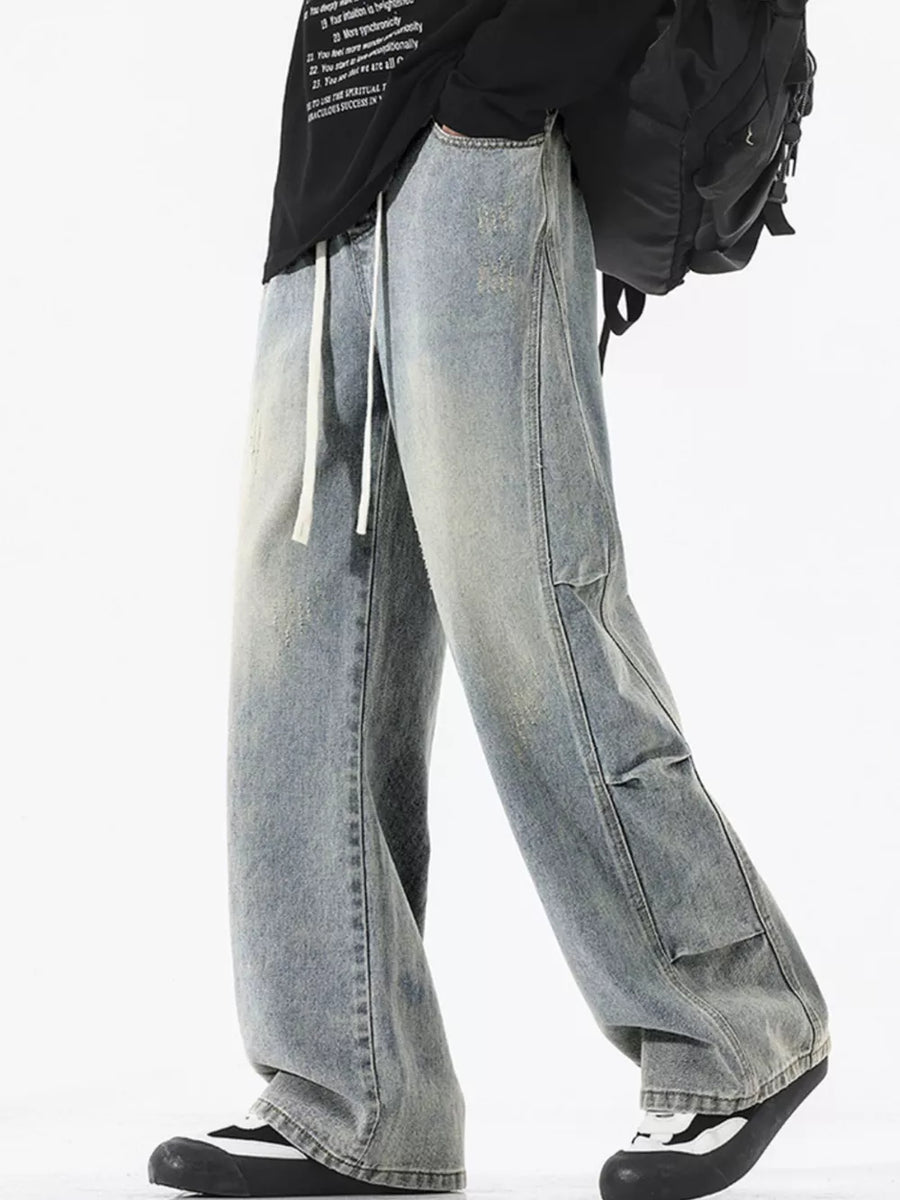 Light wash distressed wide leg jeans with drawstring and cargo pockets.