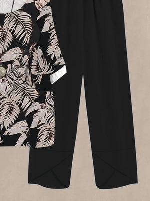 Black floral print half sleeve top with white cuffs paired with black wide leg pants.