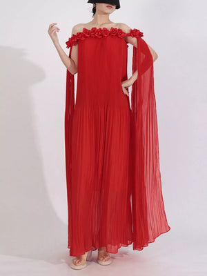 Red off-shoulder maxi dress with floral applique neckline and flowing cape sleeves.