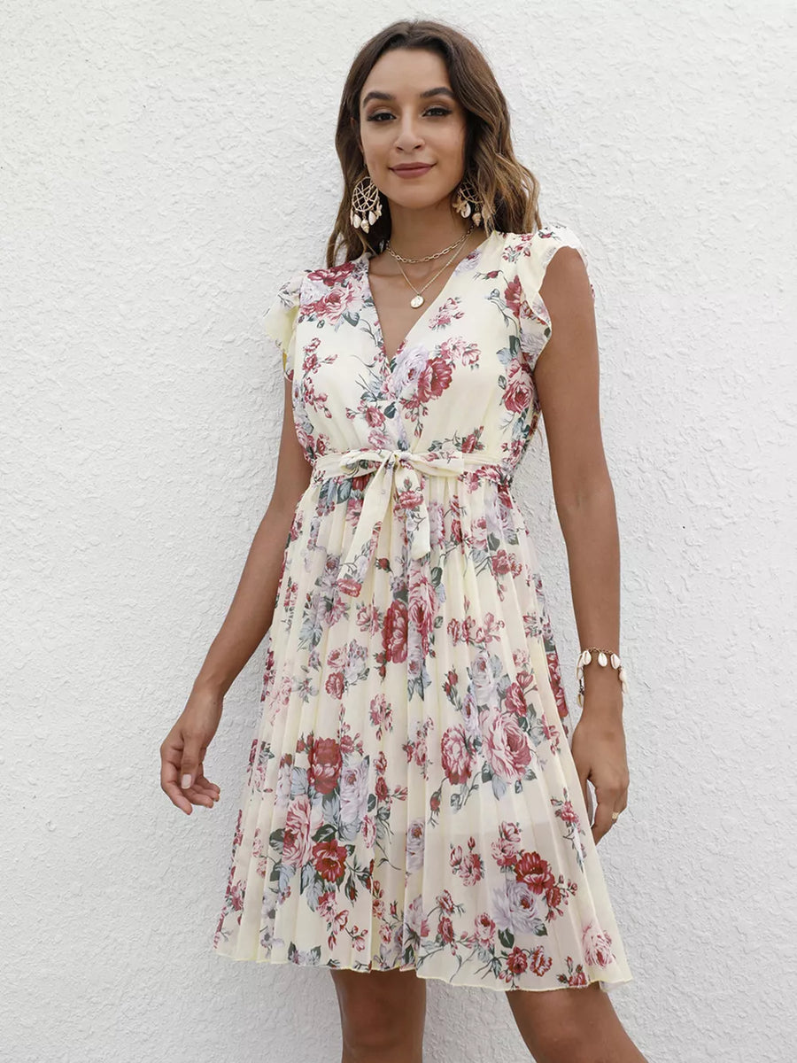 Floral pleated dress with ruffle sleeves in cream, V-neck, belted waist, and a-line skirt.