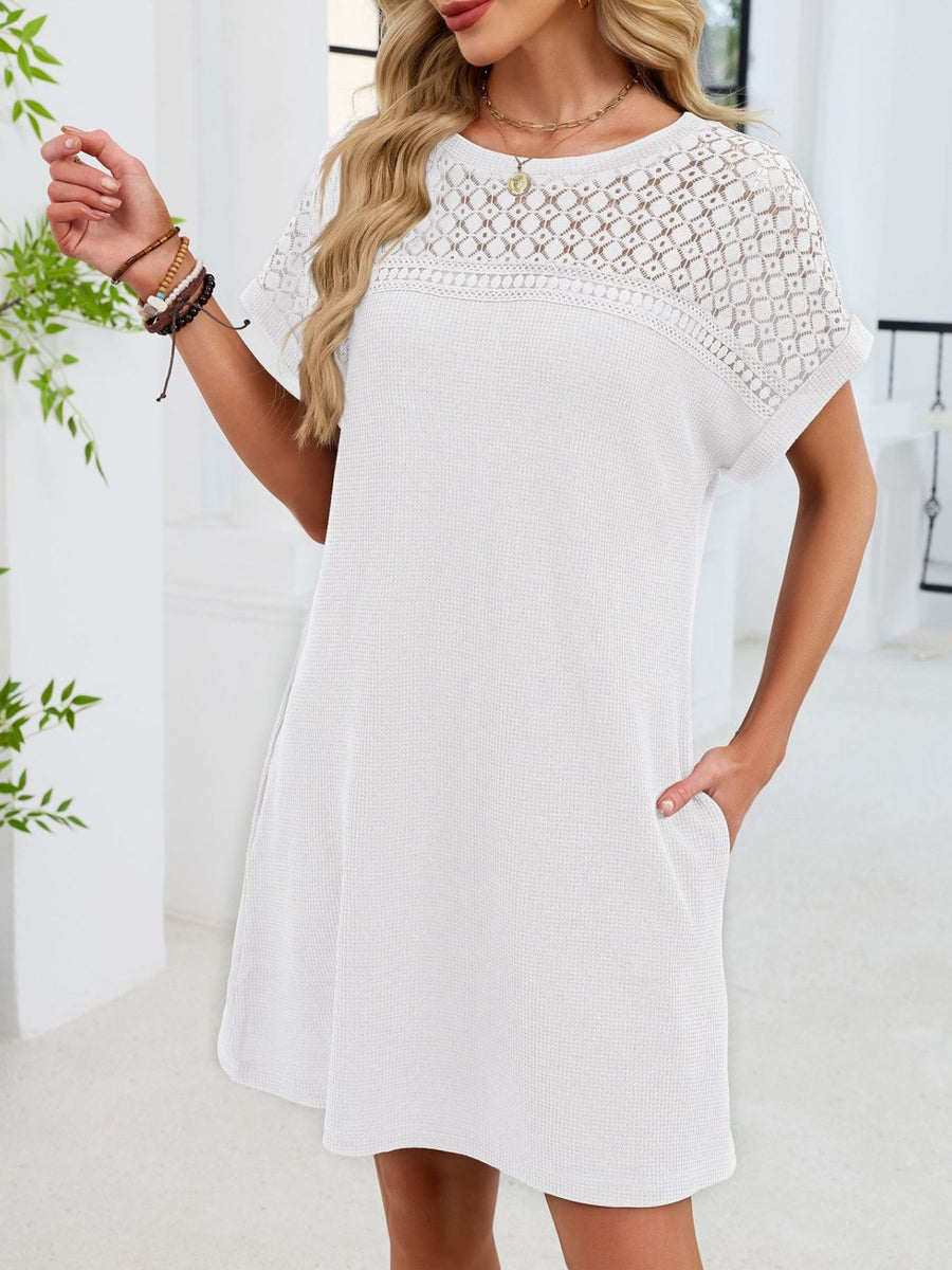 White t-shirt dress with short sleeves and a sheer lace yoke detail.
